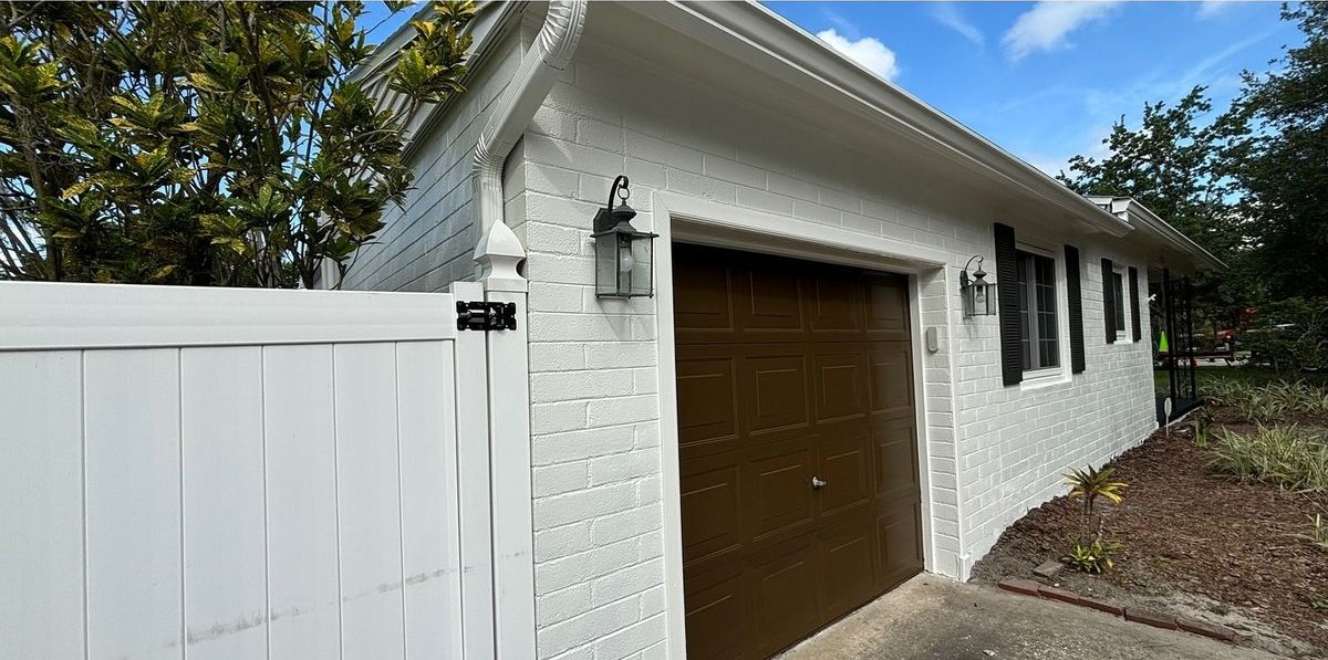 After: brick painted white, garage door painted brown and the fence washed clean